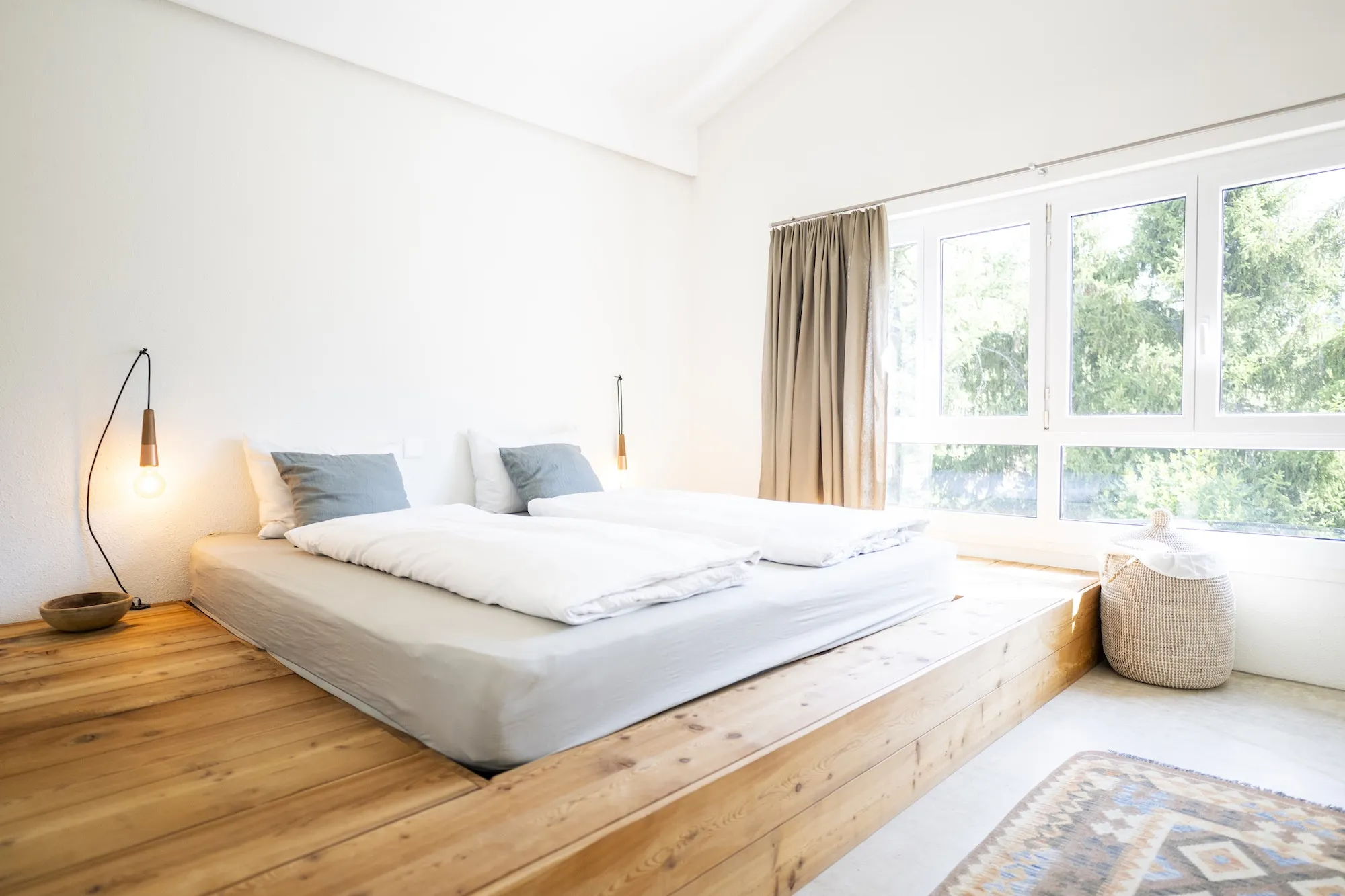 Schlafzimmer mit grossem Doppelbett und Blick ins Grüne